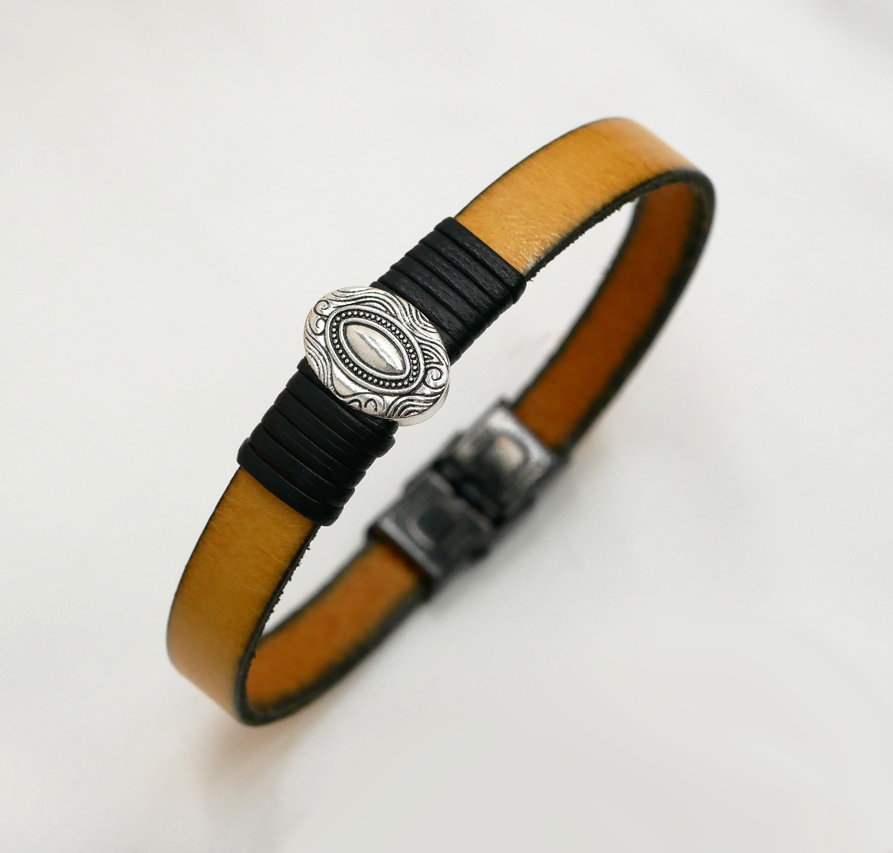 Cinturino in pelle personalizzabile con ornamento ovale centrale incorniciato da pelli pregiate 