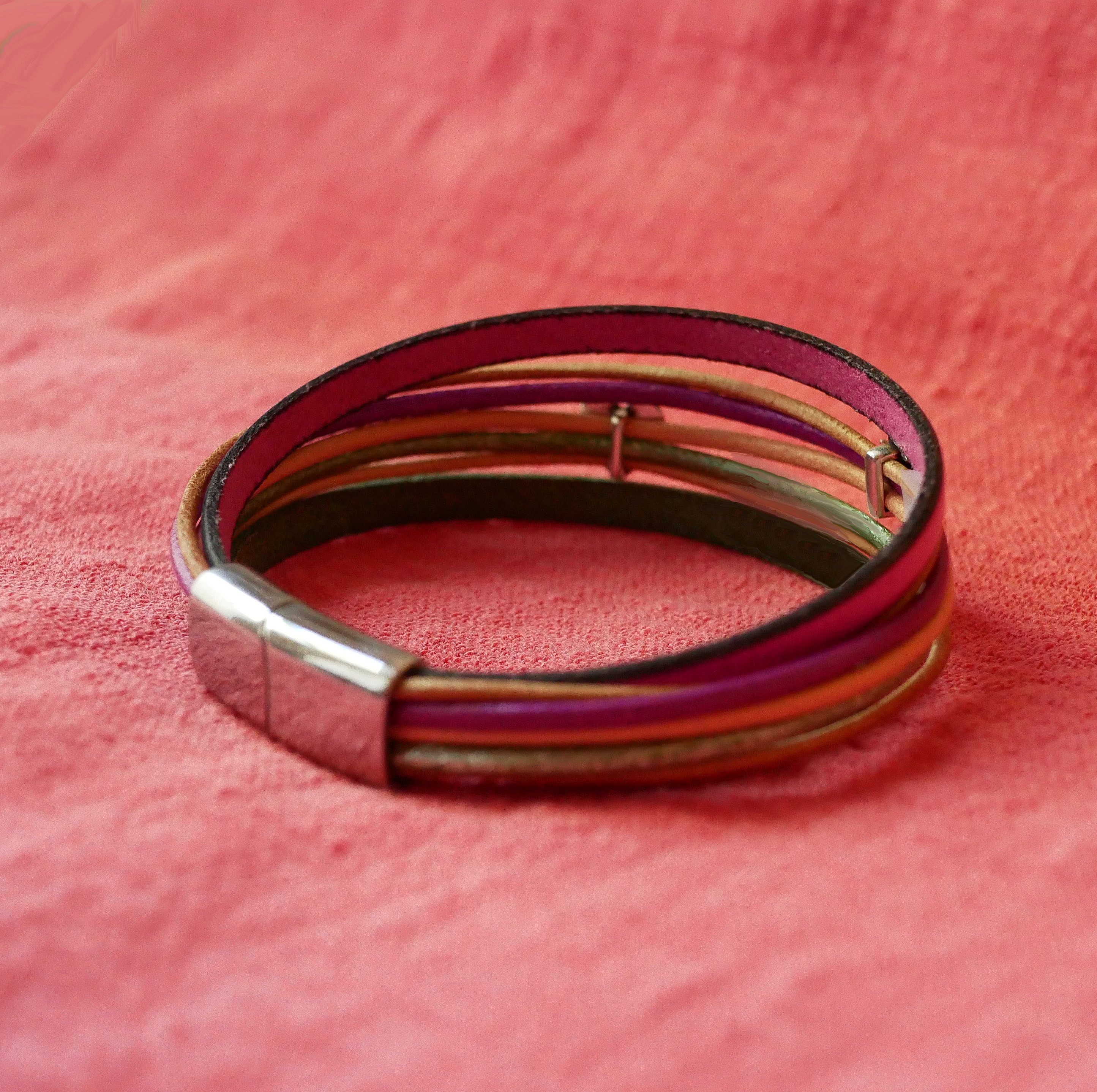 Bracelet manchette multi-cordons en cuir coloré avec fermoir argenté.