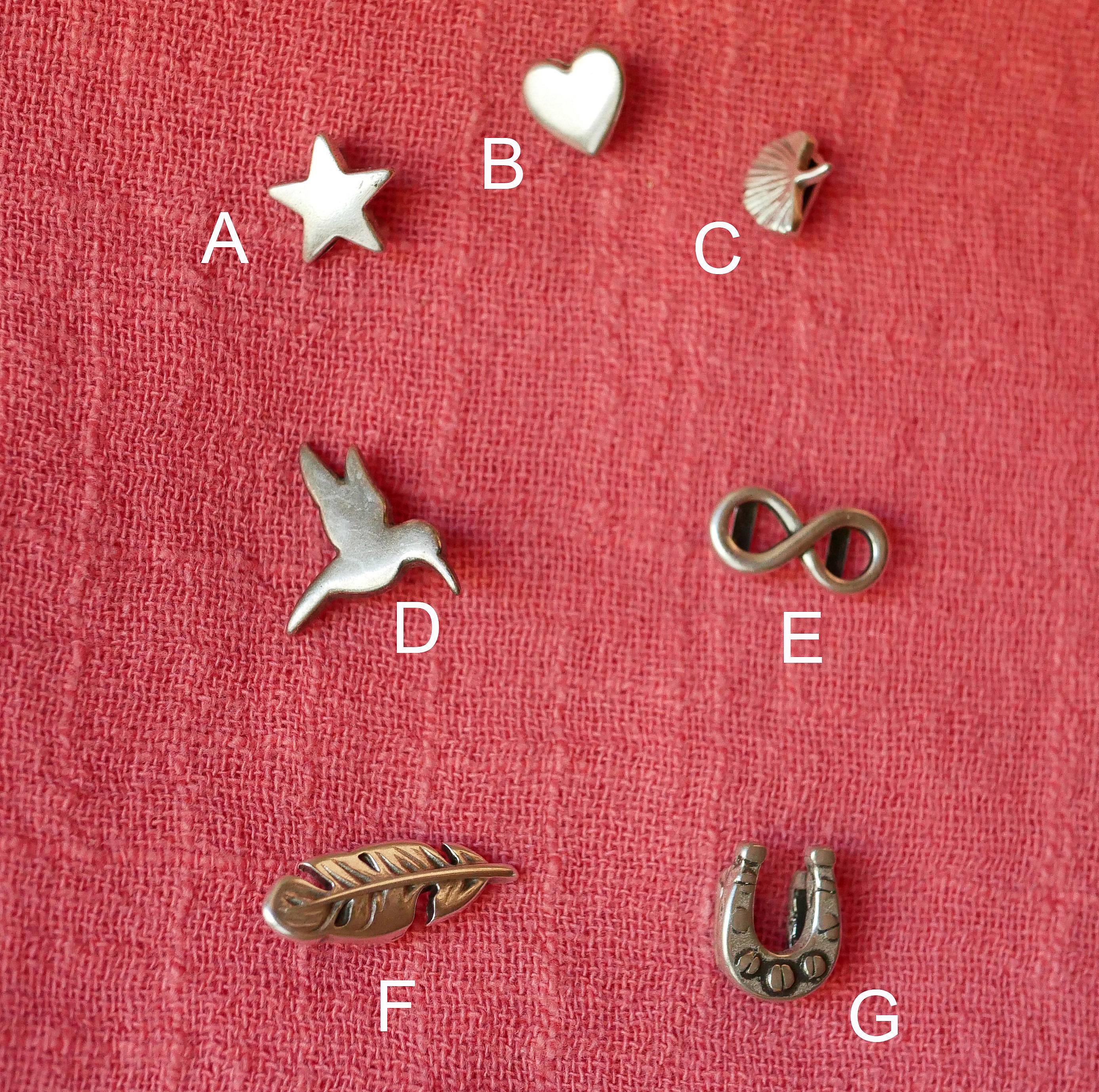 Breloques argentées pour personnalisation de bracelet en cuir.