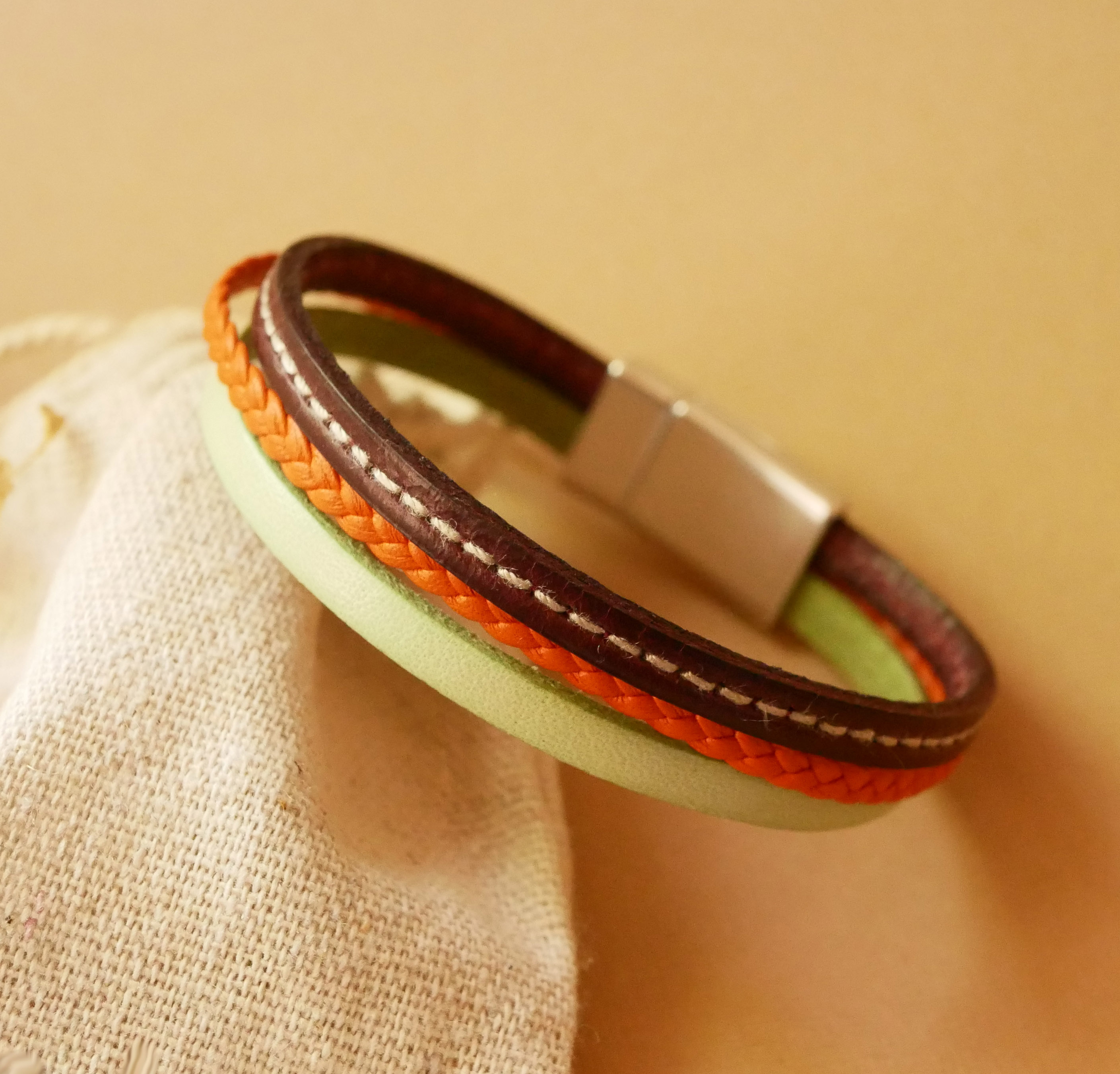 Bracciale in multi-pelle con mandorla, treccia arancione e impunture bordeaux