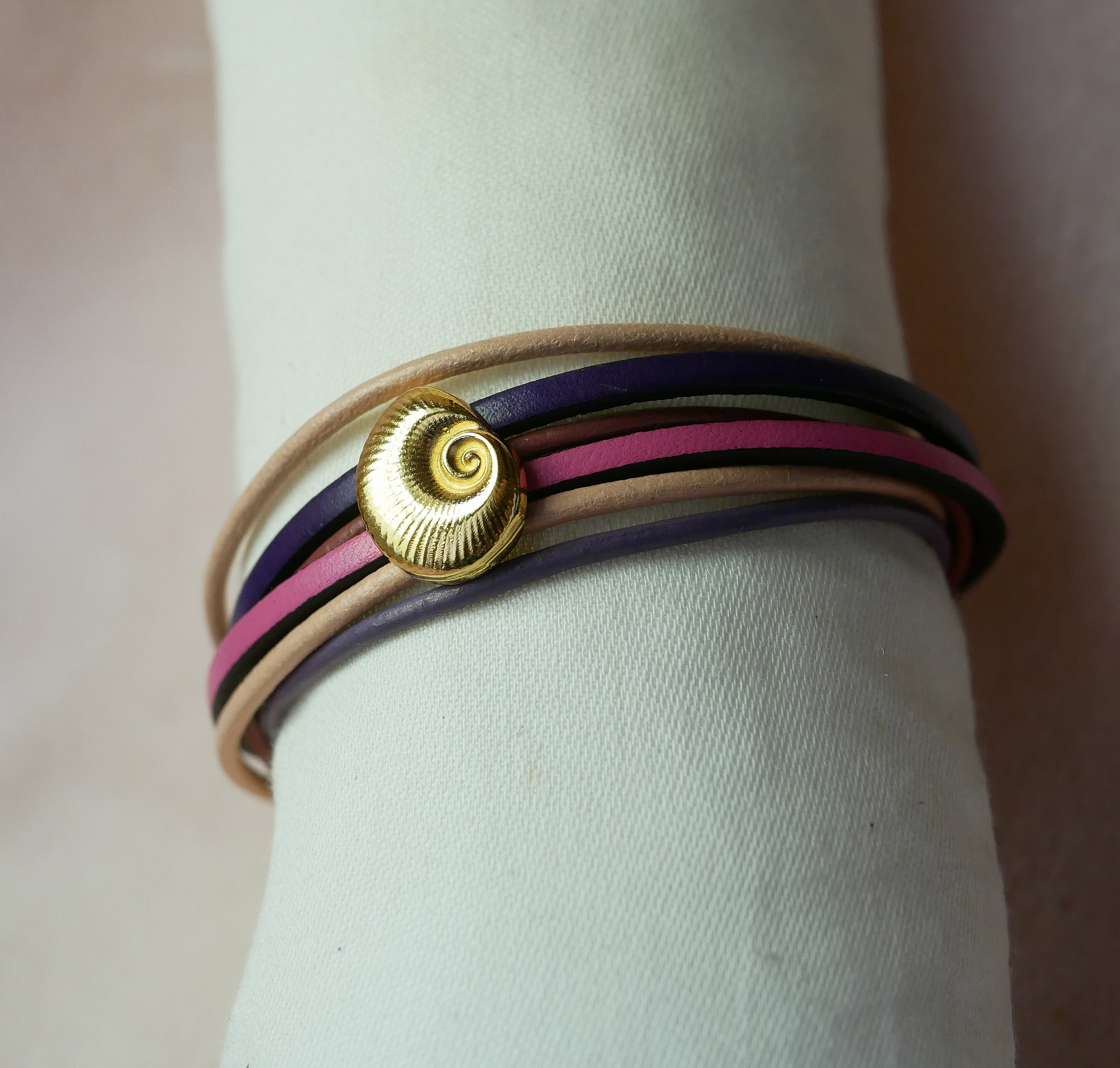 Bracciale a pi&ugrave; maglie in pelle color pesca e malva con decorazione a conchiglia dorata