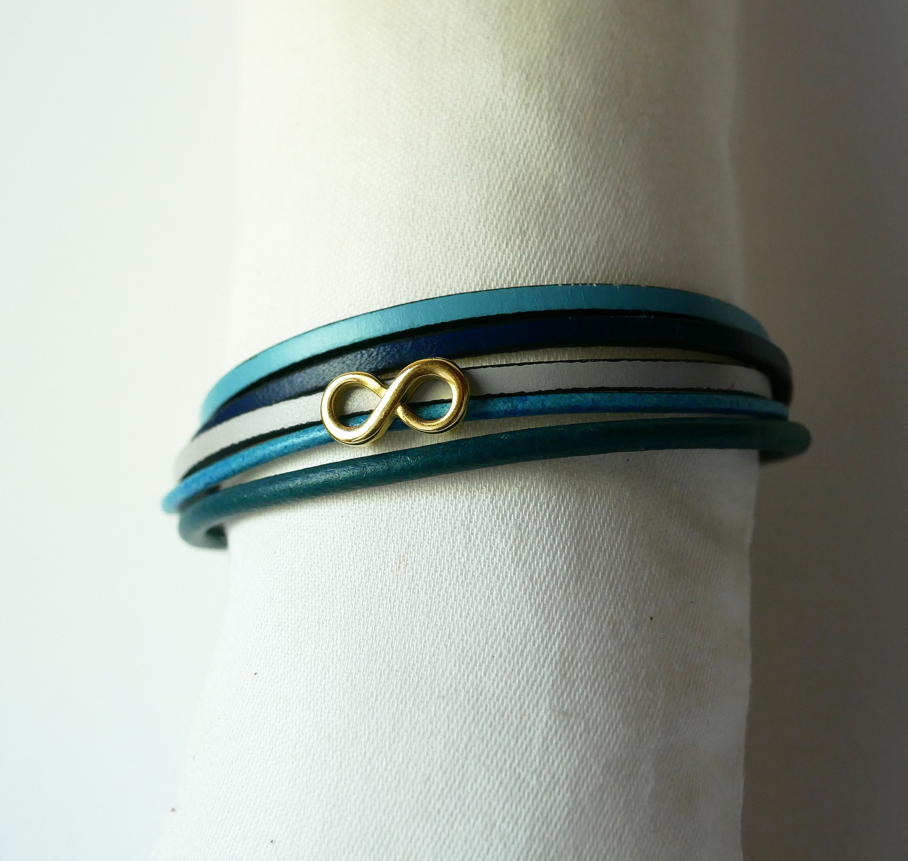 Bracciale a pi&ugrave; maglie in pelle blu con motivo infinity in oro