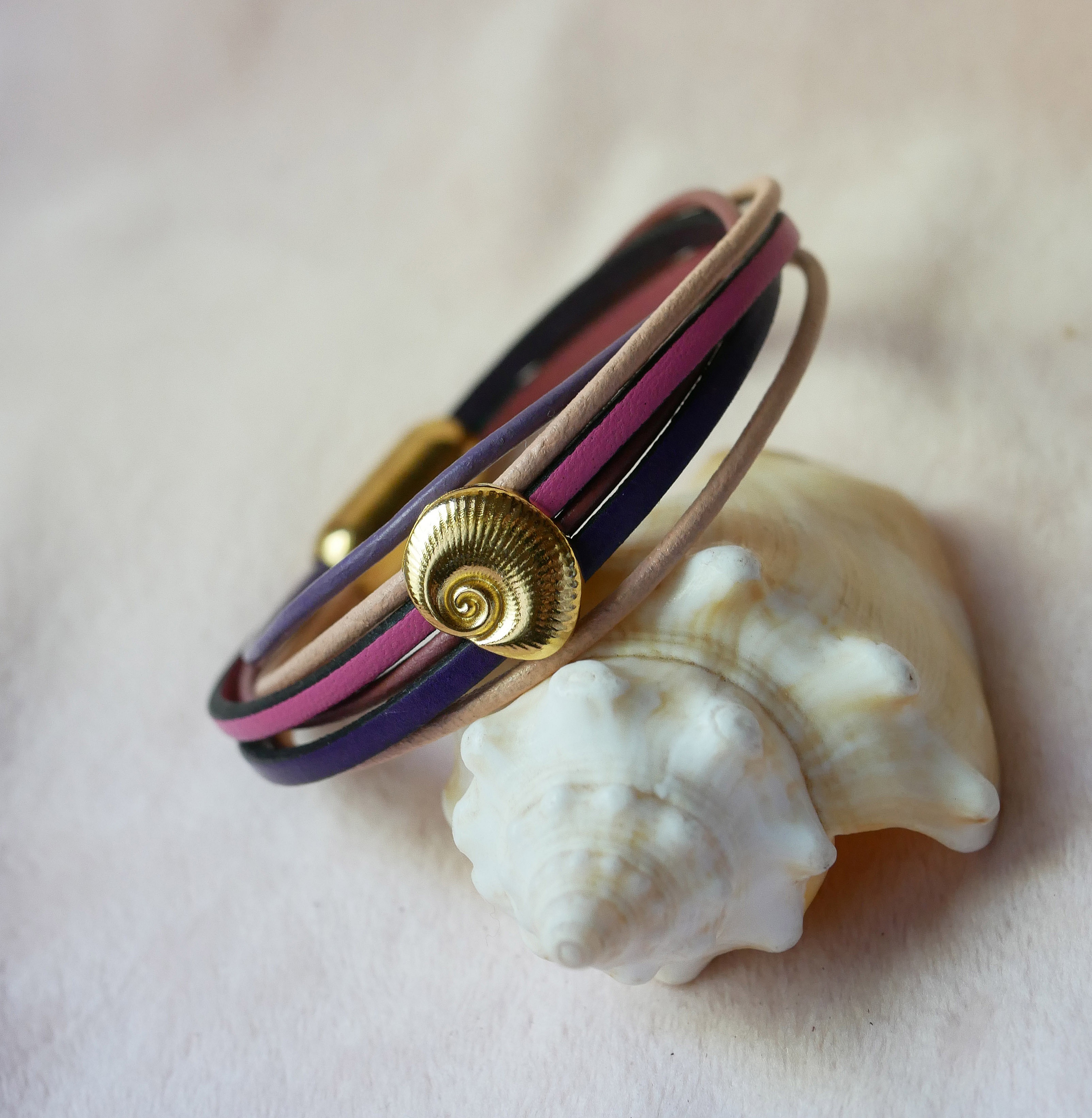 Bracciale a pi&ugrave; maglie in pelle color pesca e malva con decorazione a conchiglia dorata