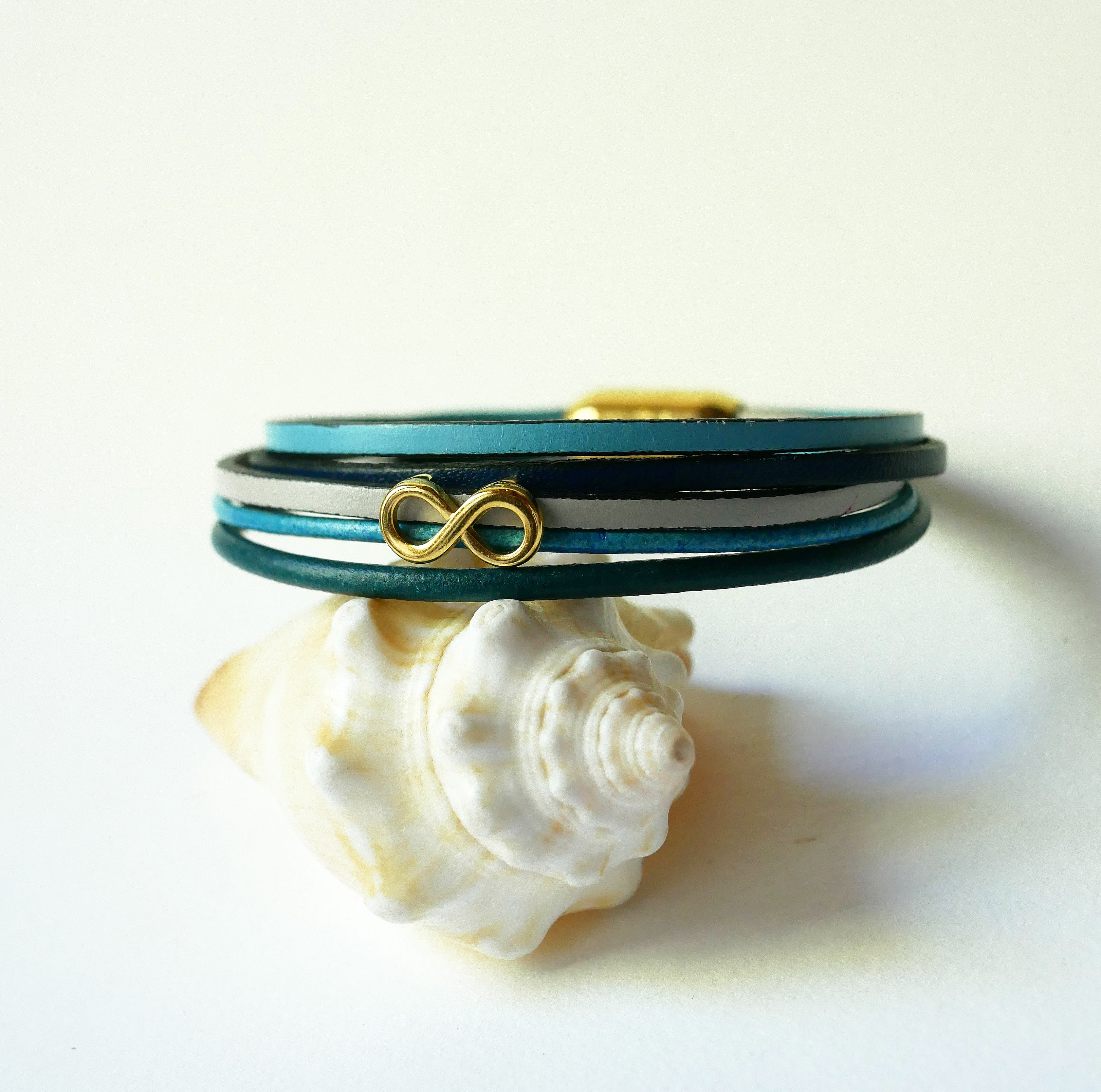 Bracciale a pi&ugrave; maglie in pelle blu con motivo infinity in oro