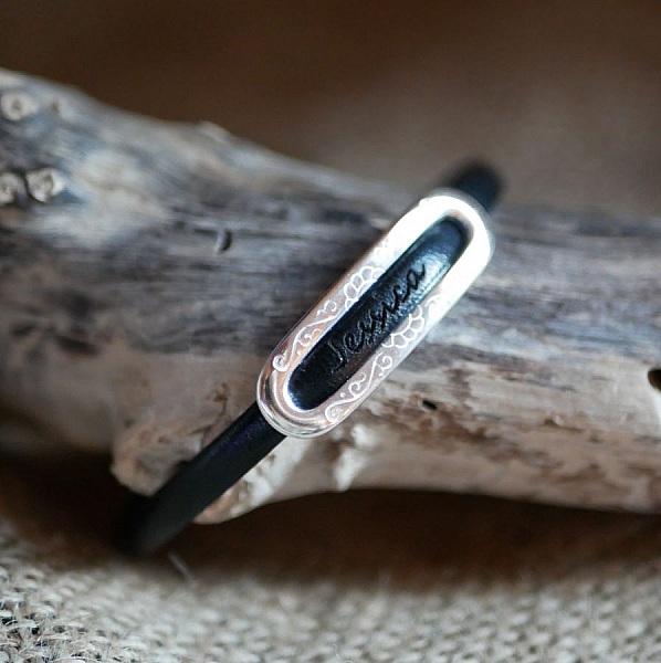 Bracelet en cuir noir avec plaque argentée gravée personnalisée.