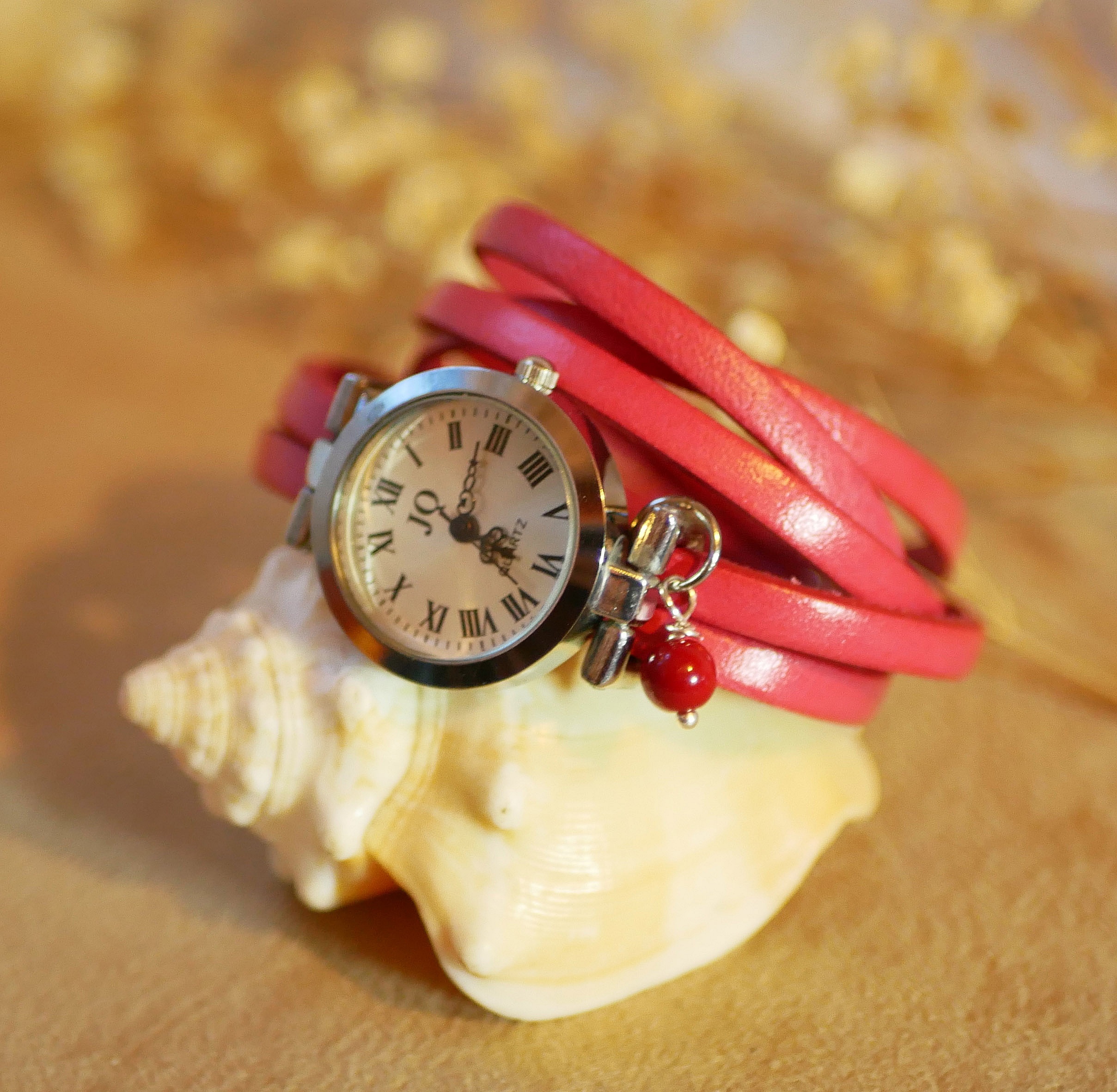 Montre argentée avec bracelet multi tours en cuir bleu.