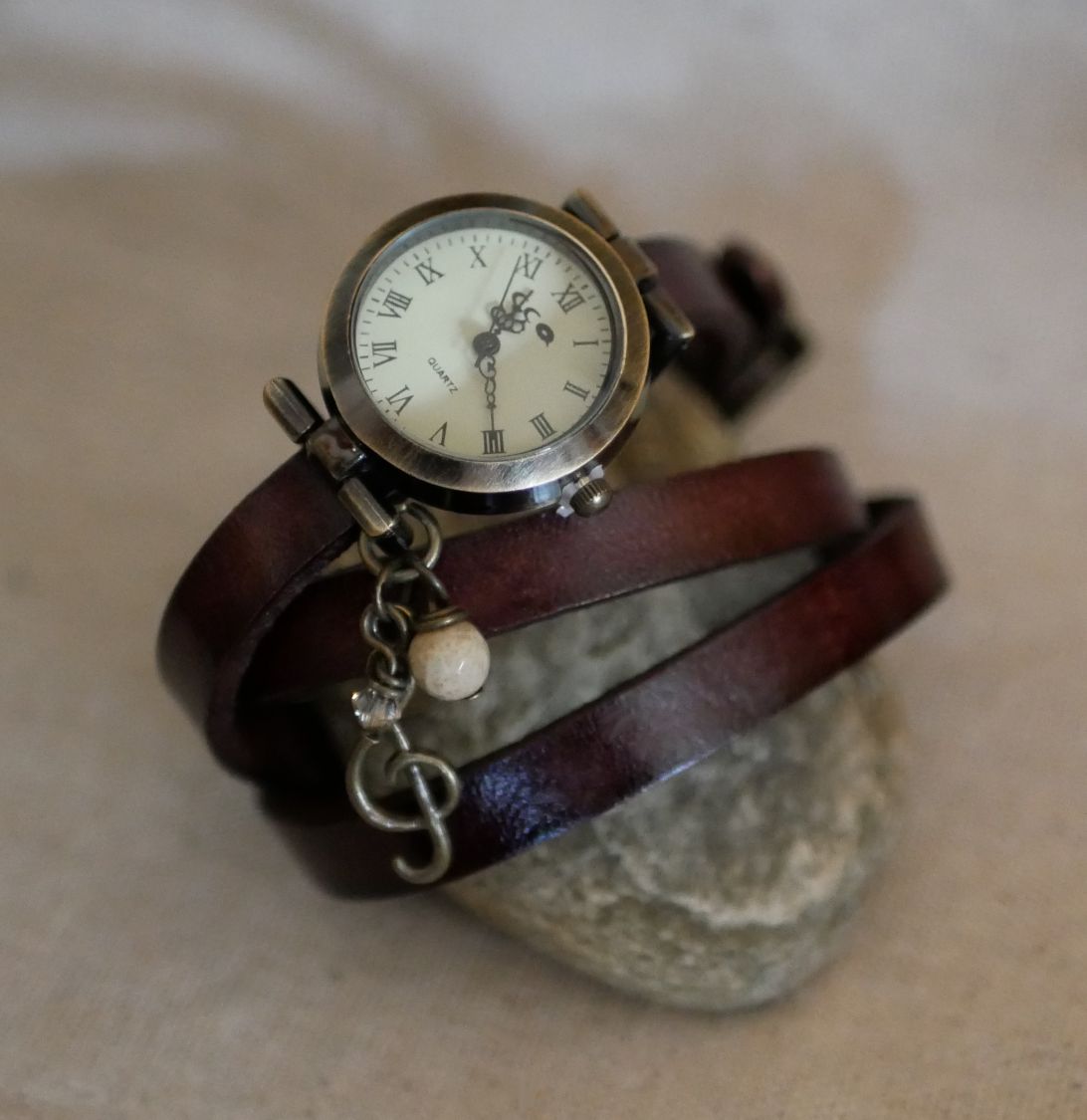 Orologio con bracciale in pelle e ciondoli con piume e perle