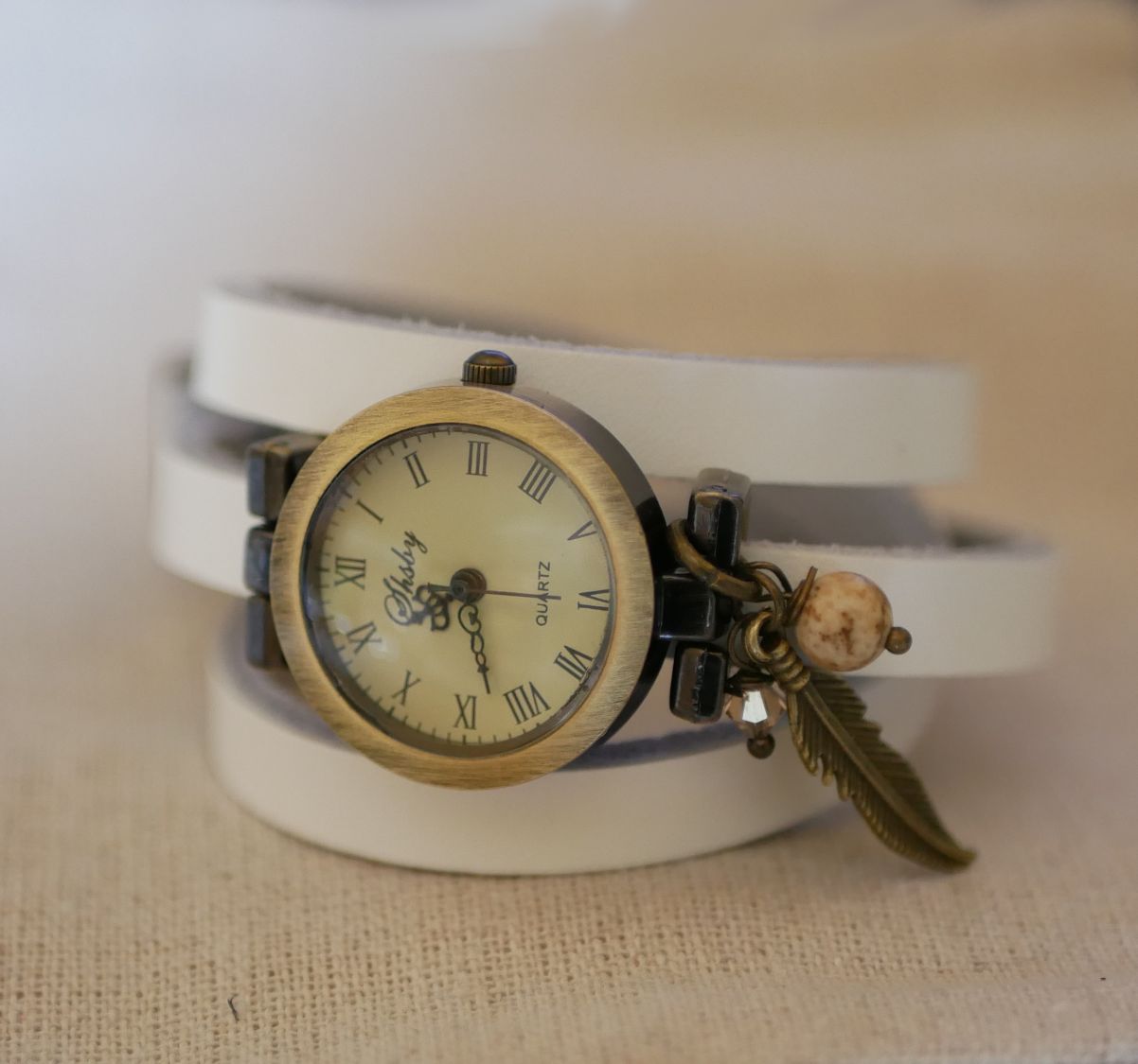 Orologio con bracciale in pelle e ciondoli con piume e perle