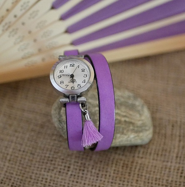 Montre femme en cuir lilas avec cadran argenté et pompon.