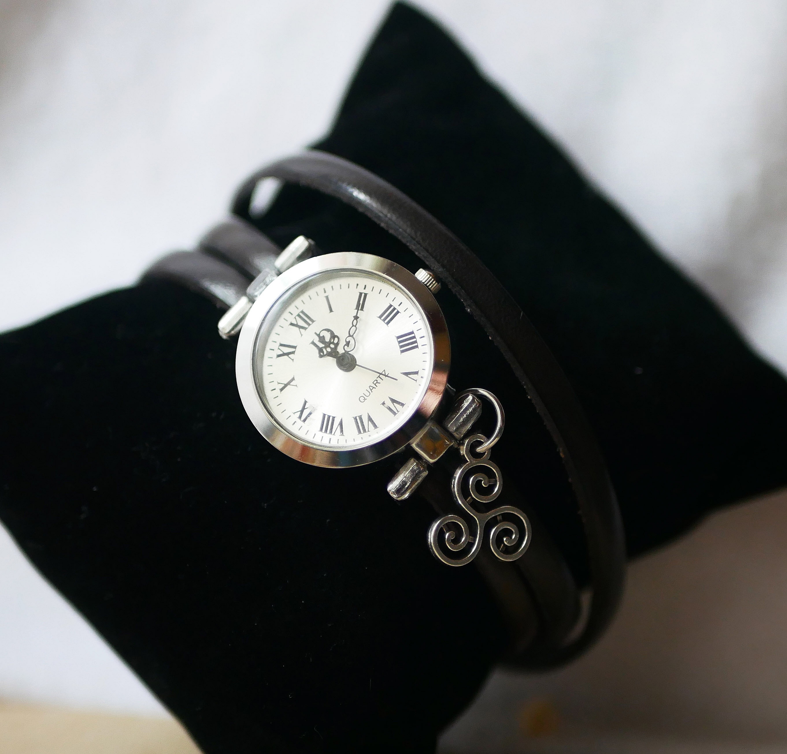Montre bracelet en cuir personnalisable avec pendentif triskel argenté.
