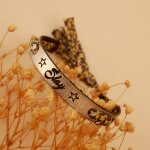 Bracciale Florâme con incisione di fiori gialli a nastro liberty su pelle argentata