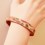 Bracciale Florâme con nastro liberty e fiori viola su pelle rosa invecchiata